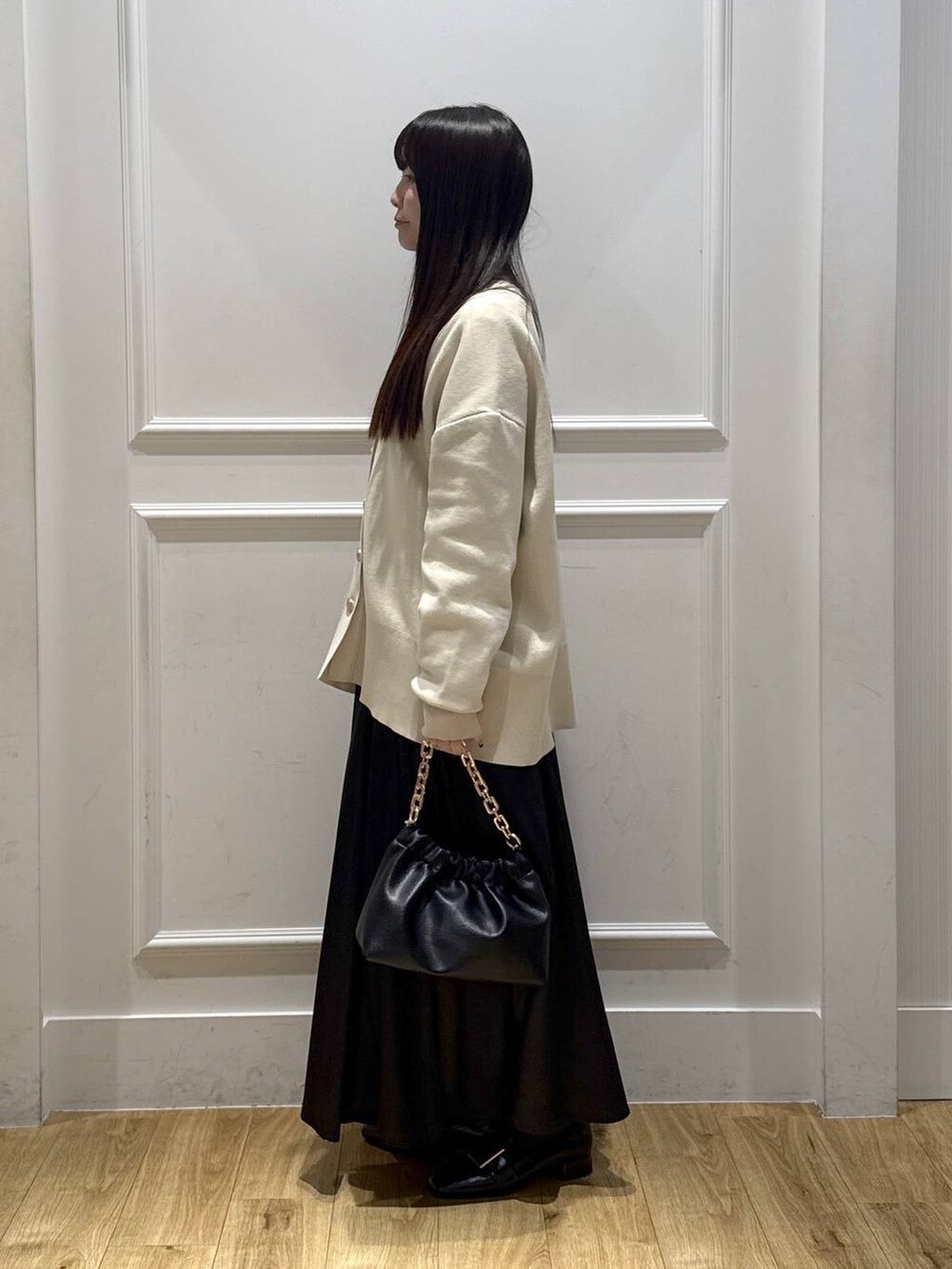 ホワイト系のカーディガン/ボレロ、ホワイト系のTシャツ/カットソー、ブラック系のショルダーバッグを着用したレディースの春コーディネートの2枚目の写真