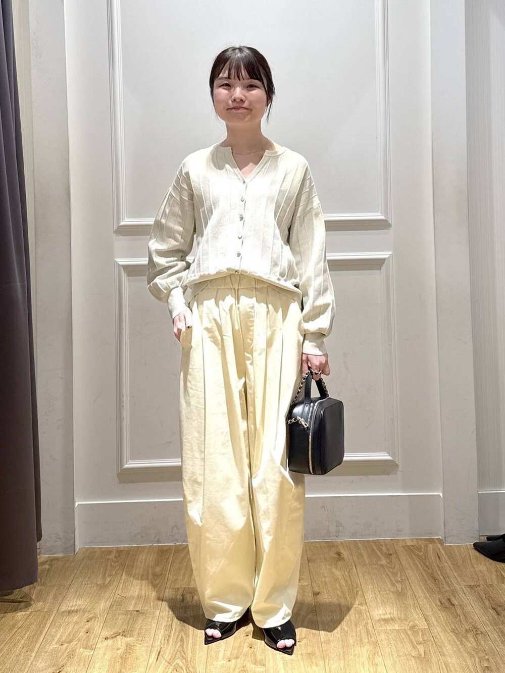 ホワイト系のカーディガン/ボレロ、ブラック系のサンダル、ブラック系のショルダーバッグを着用したレディースの春コーディネートの5枚目の写真