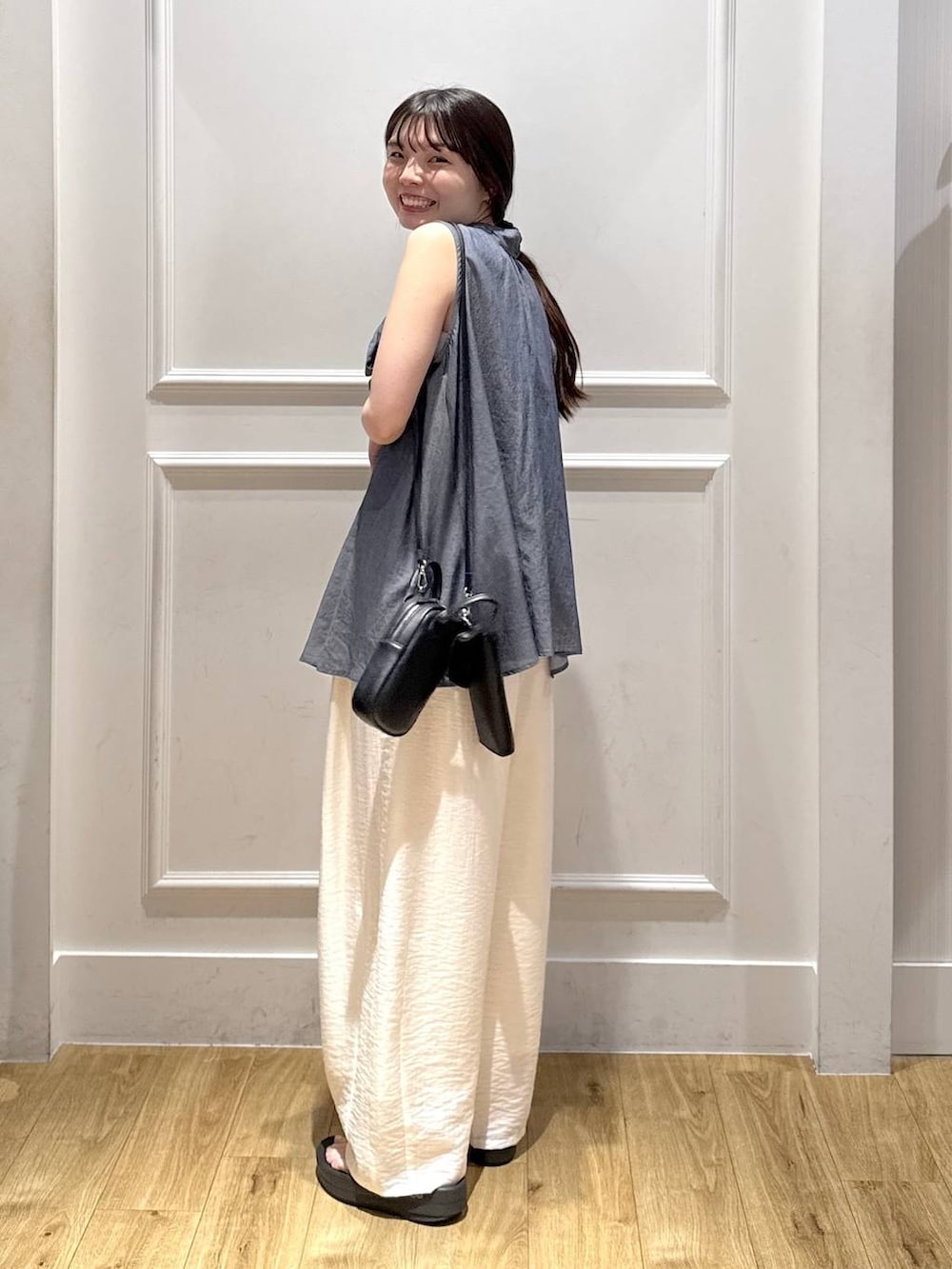 ホワイト系のその他パンツ、ブルー系のシャツ/ブラウス、ブラック系のショルダーバッグを着用したレディースの夏コーディネートの3枚目の写真