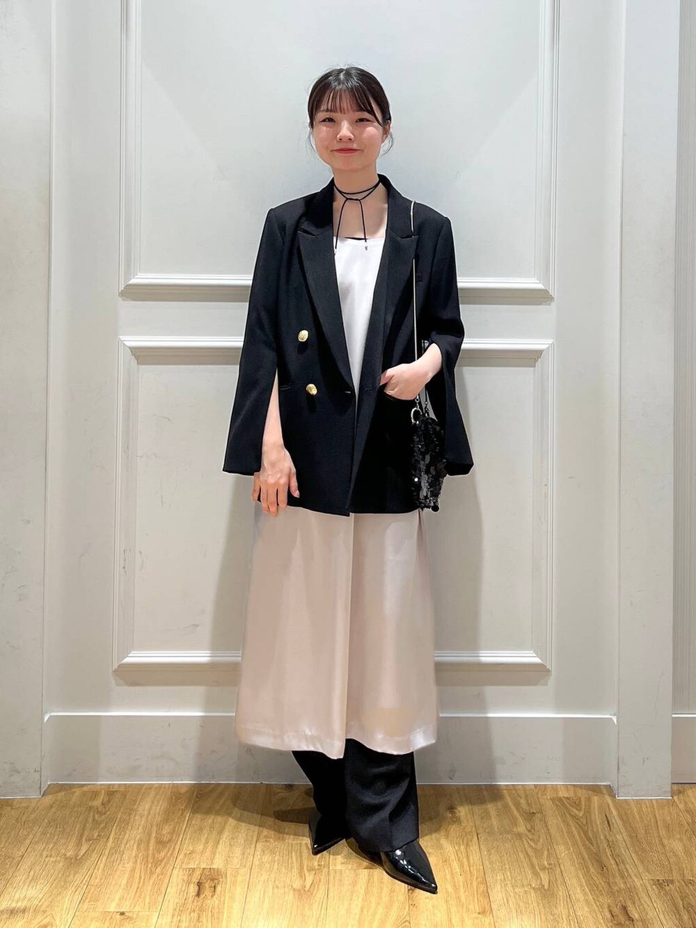 ブラック系のテーラードジャケット、ブラック系のトートバッグ、ブラック系のスラックスを着用したレディースの秋コーディネートの5枚目の写真