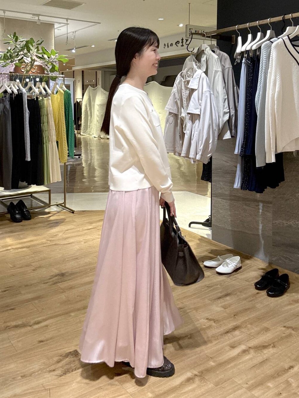 ピンク系のスカート、ブラウン系のローファー、ブラック系のショルダーバッグを着用したレディースの春コーディネートの4枚目の写真