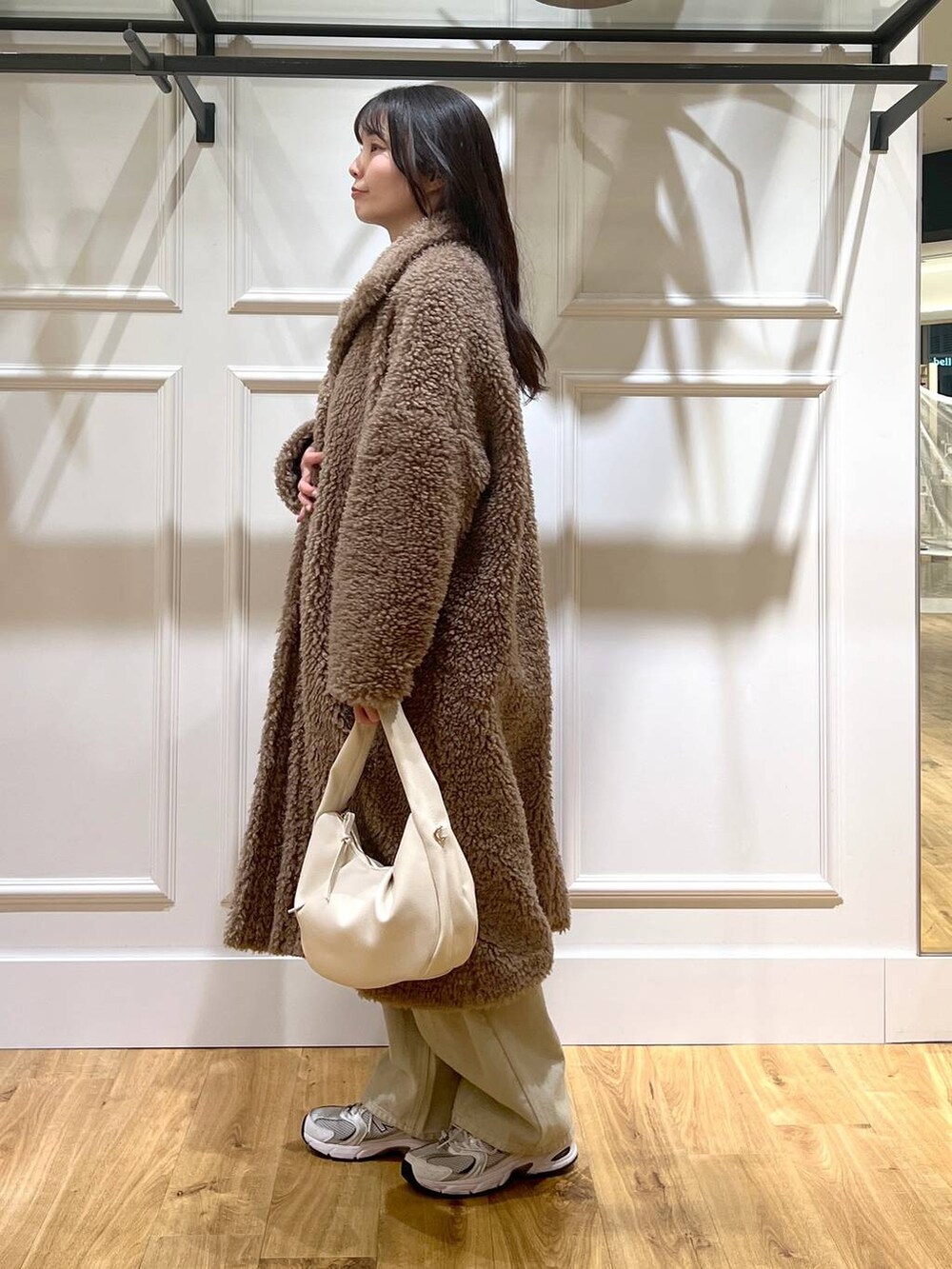ベージュ系のデニムパンツ、ホワイト系のハンドバッグ、ベージュ系のその他アウターを着用したレディースの冬コーディネートの4枚目の写真