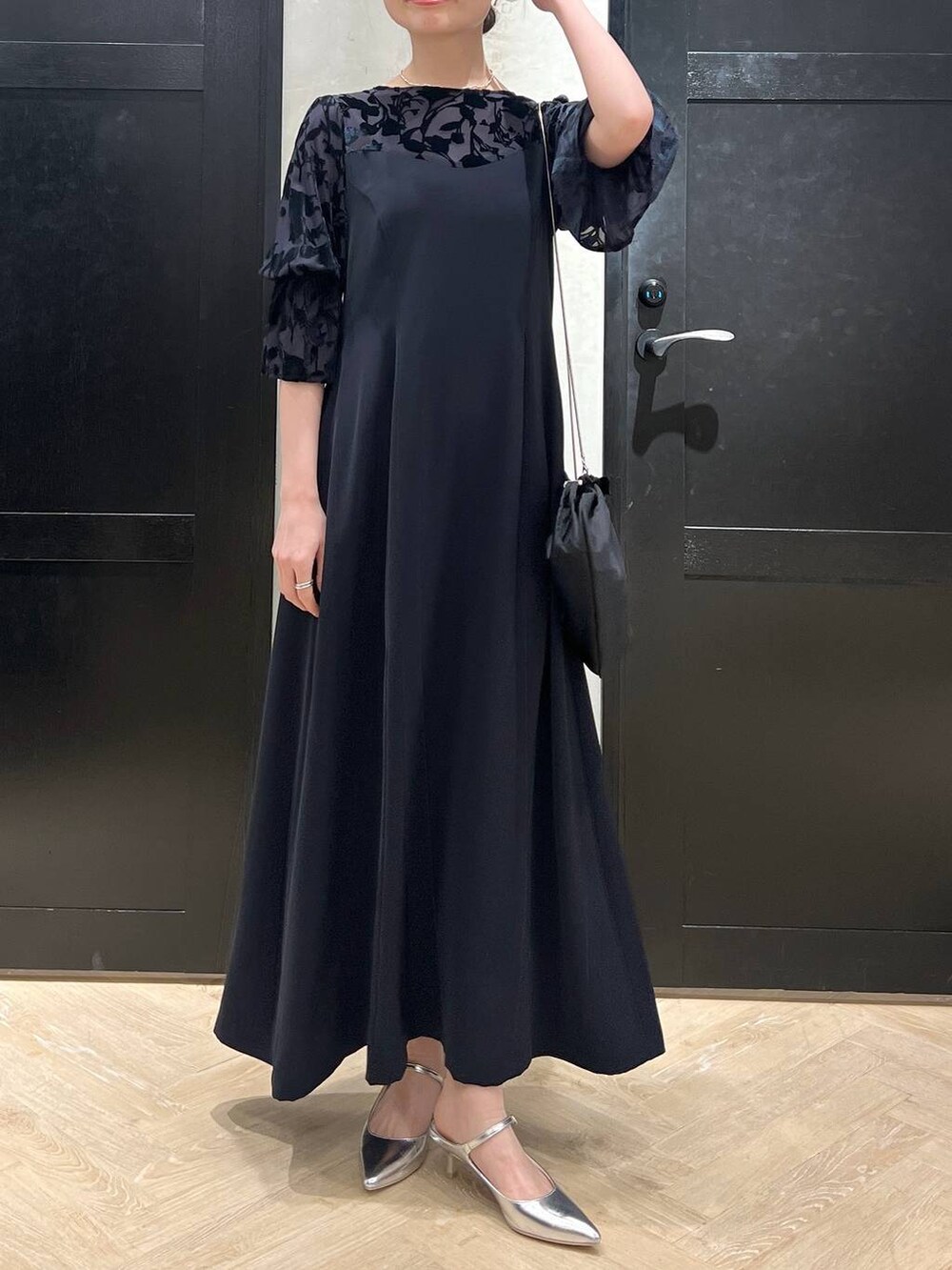 ブルー系のドレス、シルバー系のサンダル、ブラック系のショルダーバッグを着用したレディースの春コーディネートの4枚目の写真