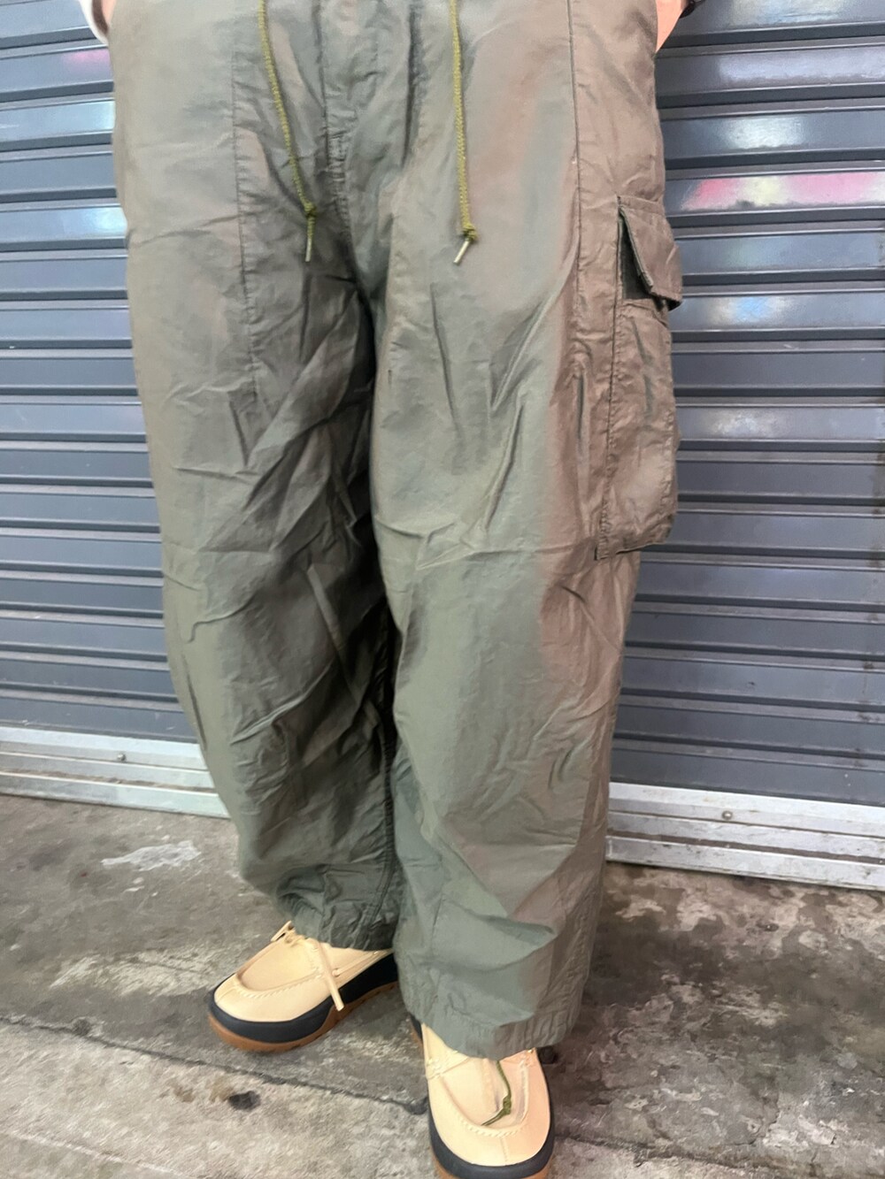 ホワイト系のスウェット、グリーン系のパンツ、ブルー系のキャップを着用したメンズの冬コーディネートの3枚目の写真