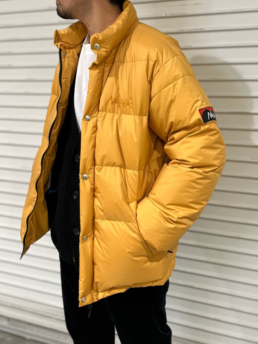 ブラック系のその他パンツ、ブラック系のモカシン/デッキシューズ、ホワイト系のカーディガン/ボレロを着用したメンズの冬コーディネートの2枚目の写真