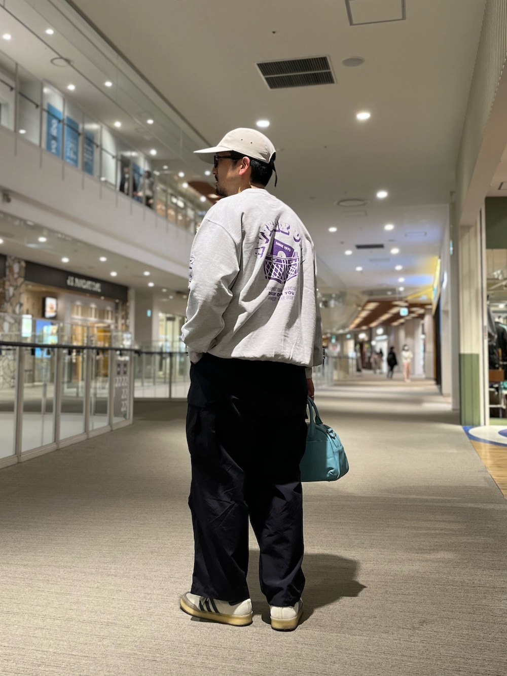 ブルー系のボストンバッグ、ブルー系のTシャツ/カットソー、グレー系のスウェットを着用したメンズの冬コーディネートの2枚目の写真