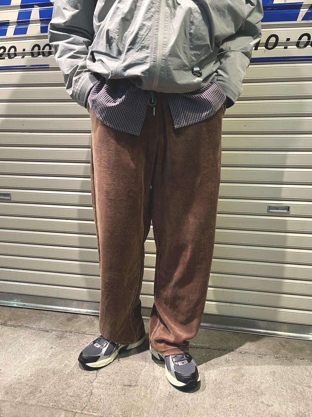 グレー系のマウンテンパーカー、ブラウン系のパンツ、ブラック系のシューズを着用したメンズの秋コーディネートの5枚目の写真