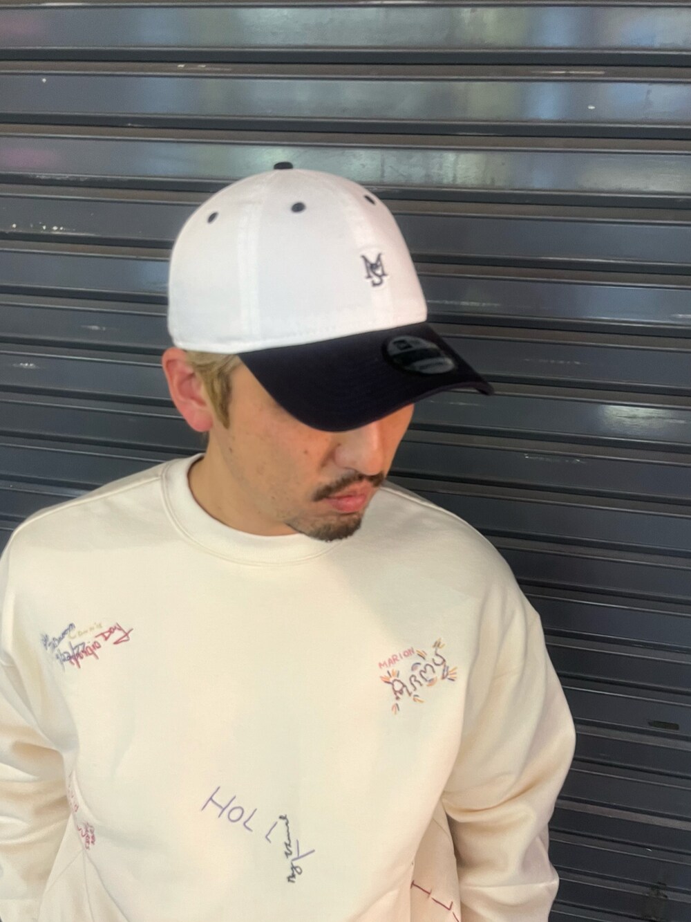 ホワイト系のスウェット、グリーン系のパンツ、ブルー系のキャップを着用したメンズの冬コーディネートの4枚目の写真