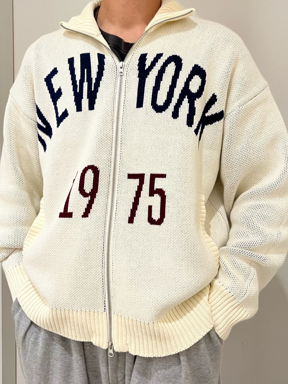 ホワイト系のニット/セーター、ブルー系のキャップを着用したメンズの秋コーディネートの2枚目の写真