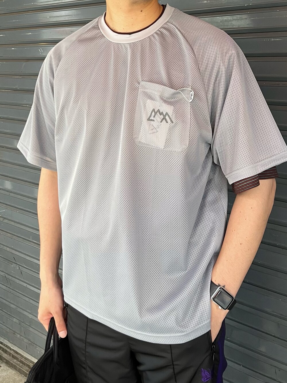 グレー系のTシャツ/カットソー、ブラック系のパンツ、ブラック系のショルダーバッグを着用したメンズの春コーディネートの2枚目の写真