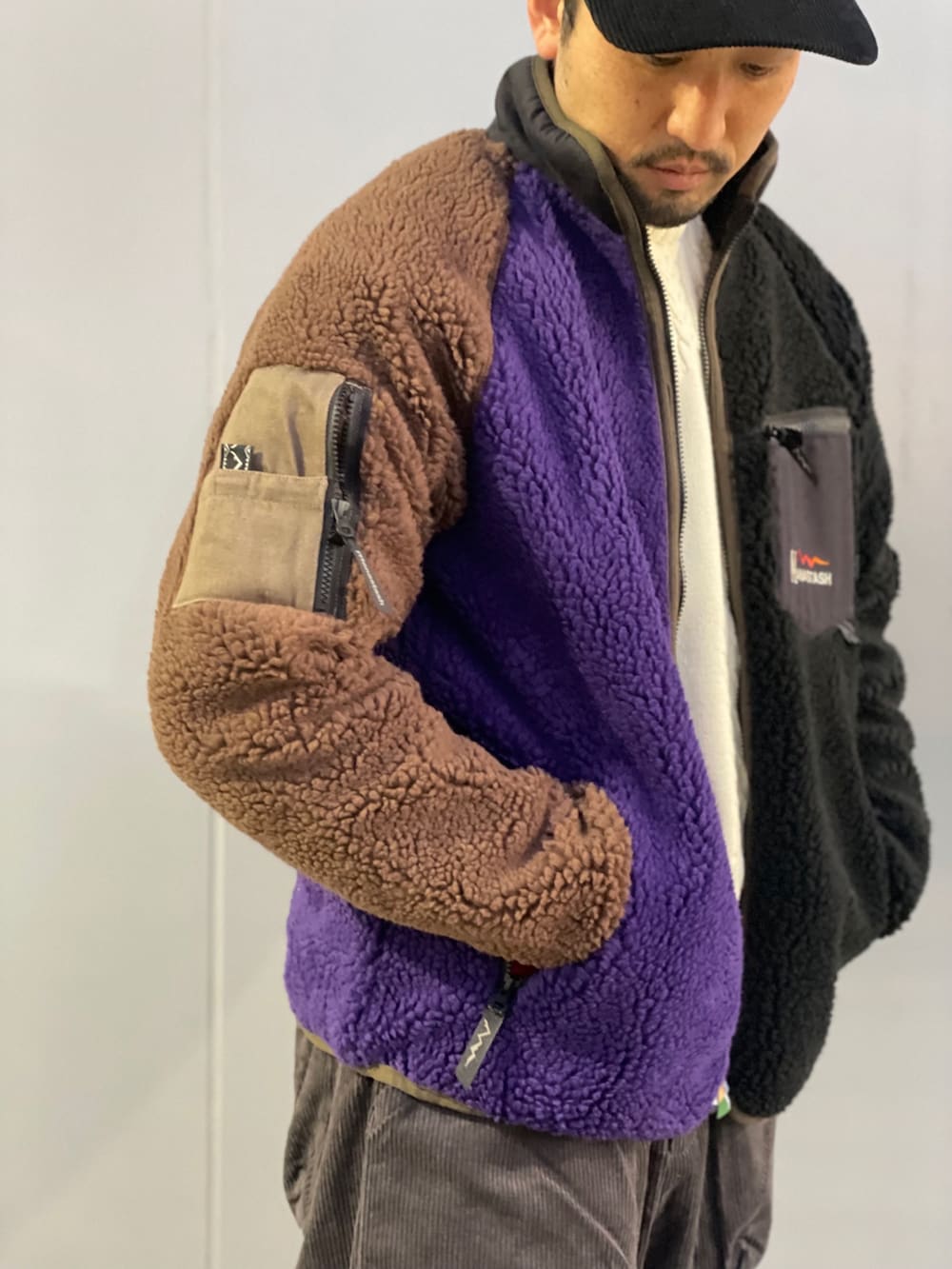 グレー系のチノパンツ、ブラック系のスニーカー、ホワイト系のニット/セーターを着用したメンズの秋コーディネートの3枚目の写真