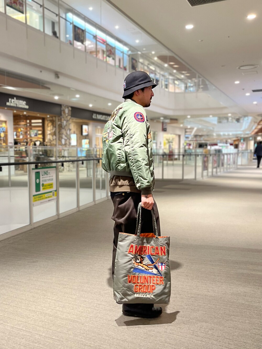 その他のMA-1、ベージュ系のトップス、グリーン系のトートバッグを着用したメンズの冬コーディネートの3枚目の写真