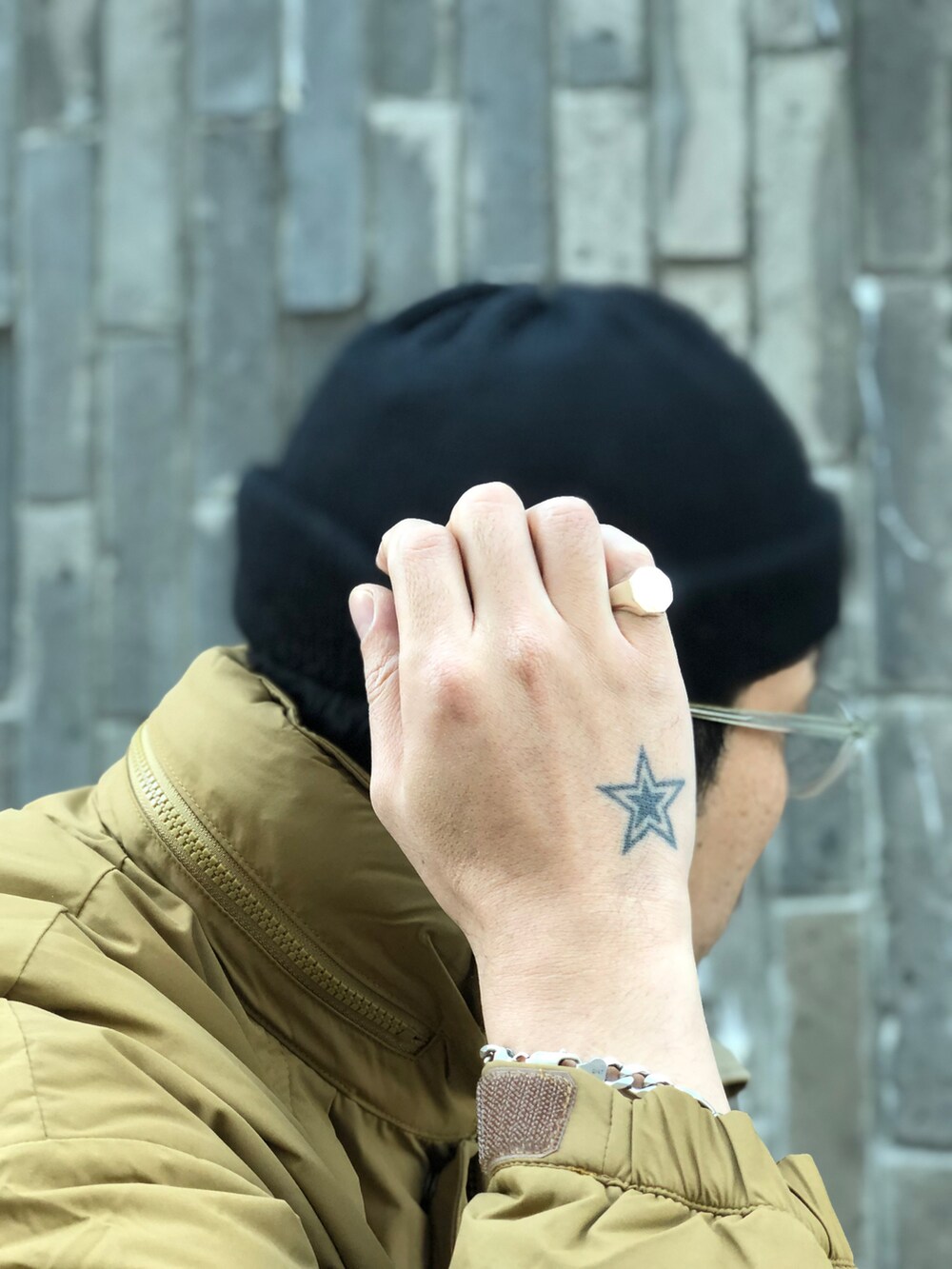 ブラック系のスウェットパンツ、ベージュ系のステンカラーコート、ブラック系のニットキャップ/ビーニーを着用したメンズの冬コーディネートの3枚目の写真