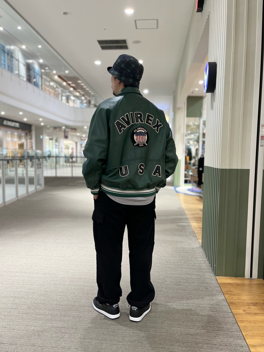 その他のTシャツ/カットソー、グリーン系のスタジャン、ブラック系のカーゴパンツを着用したメンズの冬コーディネートの2枚目の写真