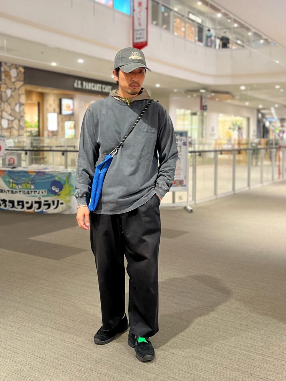 ブルー系のショルダーバッグ、グレー系のTシャツ/カットソー、グリーン系のキャップを着用したメンズの夏コーディネートの2枚目の写真