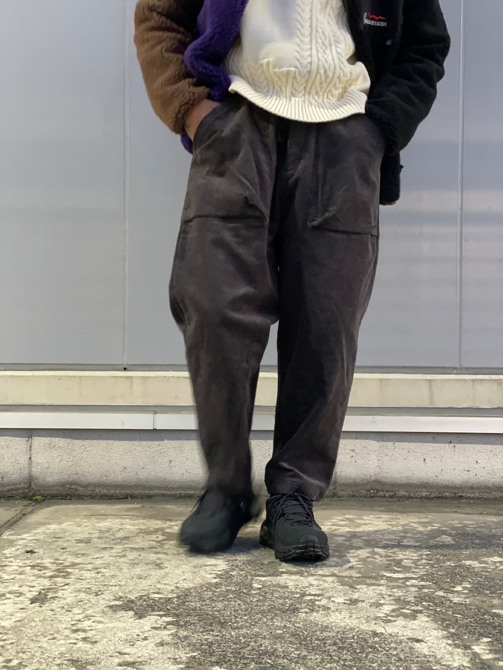 グレー系のチノパンツ、ブラック系のスニーカー、ホワイト系のニット/セーターを着用したメンズの秋コーディネートの4枚目の写真
