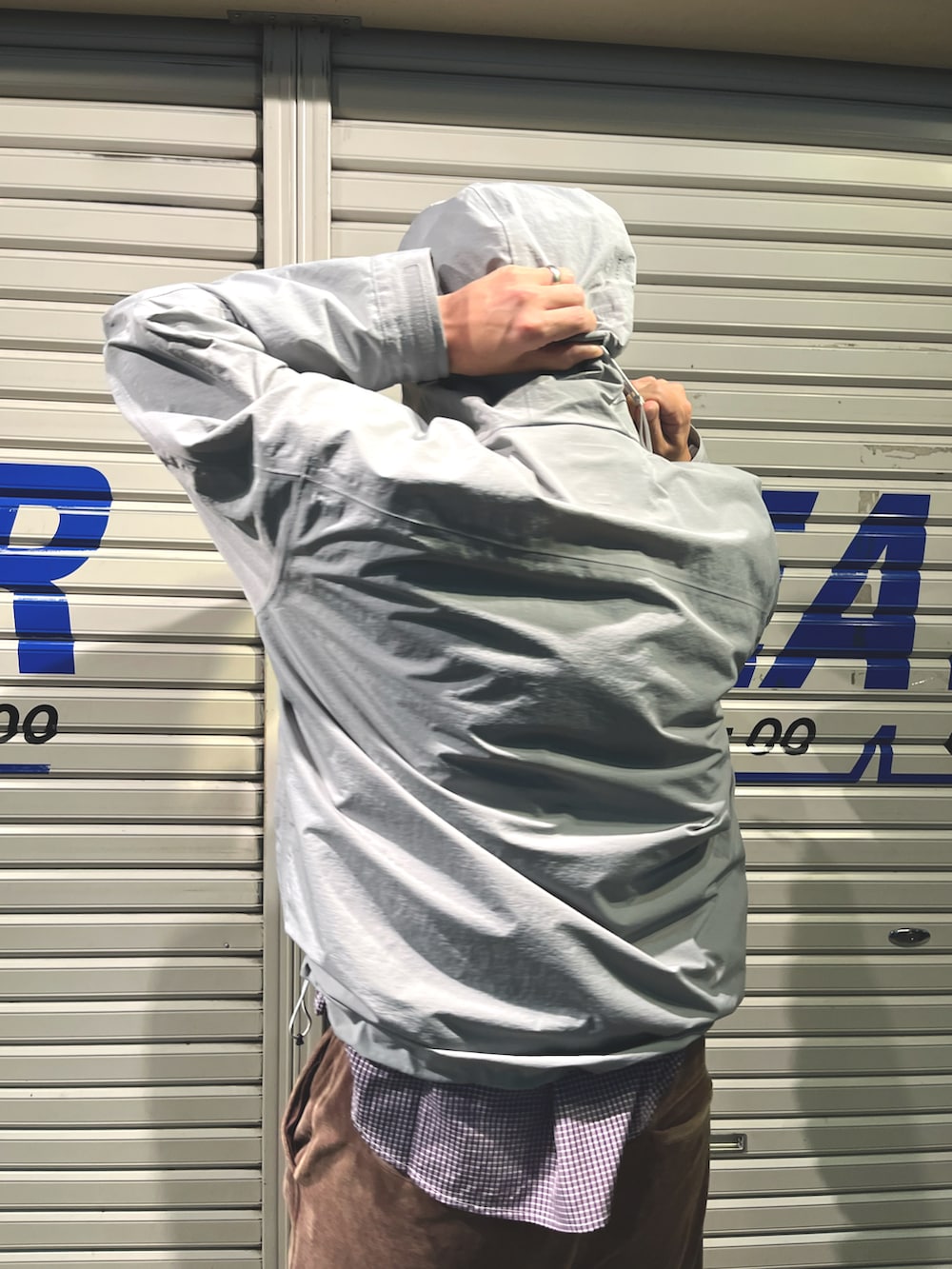 グレー系のマウンテンパーカー、ブラウン系のパンツ、ブラック系のシューズを着用したメンズの秋コーディネートの4枚目の写真