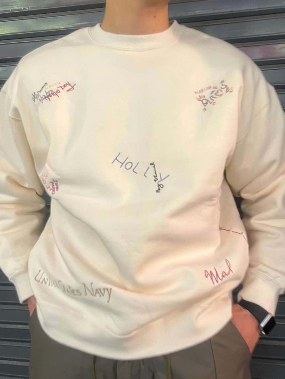 ホワイト系のスウェット、グリーン系のパンツ、ブルー系のキャップを着用したメンズの冬コーディネートの2枚目の写真