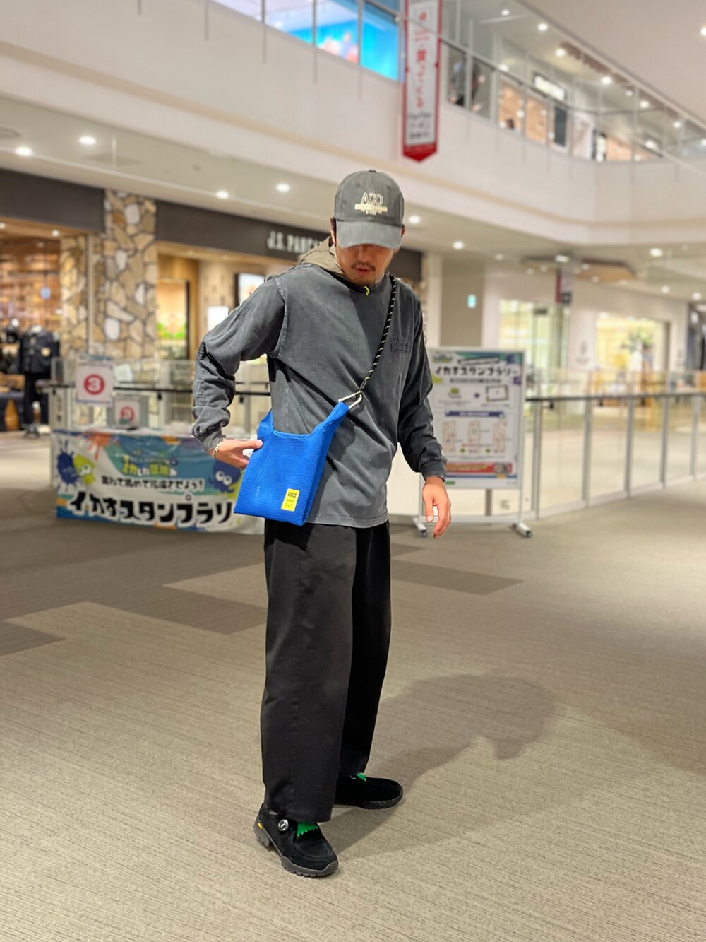 ブルー系のショルダーバッグ、グレー系のTシャツ/カットソー、グリーン系のキャップを着用したメンズの夏コーディネートの3枚目の写真