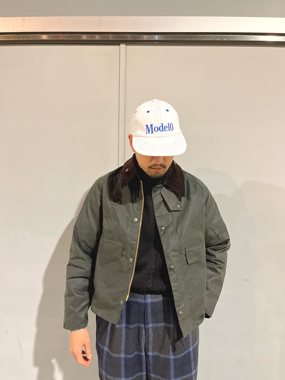 ブラック系のニット/セーター、ブルー系のスラックス、グリーン系のブルゾンを着用したメンズの秋コーディネートの3枚目の写真