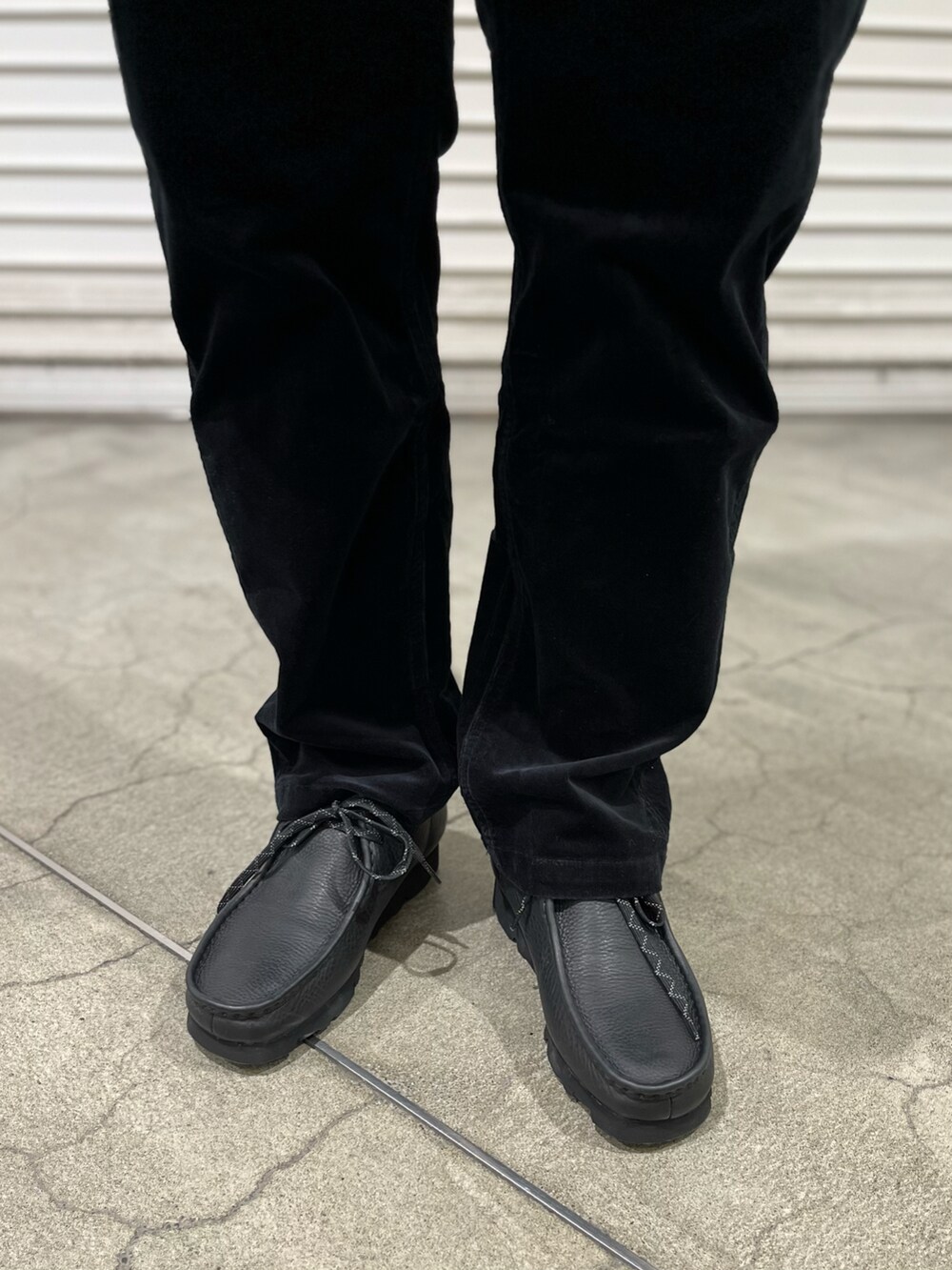 ブラック系のその他パンツ、ブラック系のモカシン/デッキシューズ、ホワイト系のカーディガン/ボレロを着用したメンズの冬コーディネートの3枚目の写真