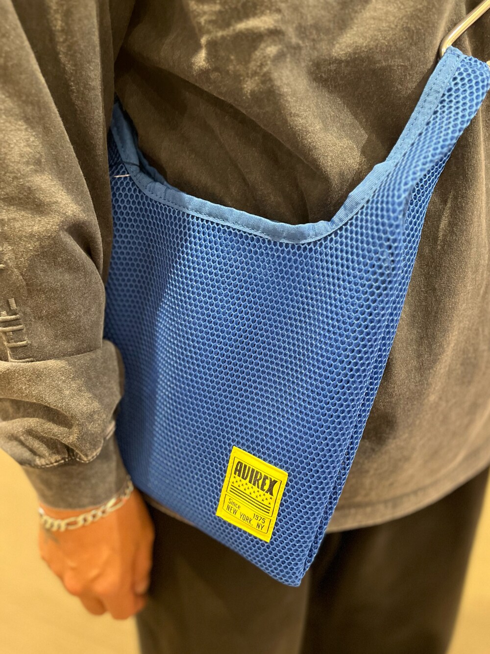 ブルー系のショルダーバッグ、グレー系のTシャツ/カットソー、グリーン系のキャップを着用したメンズの夏コーディネートの5枚目の写真