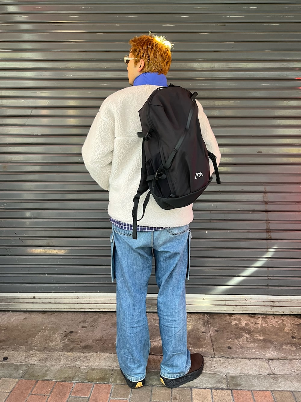 ベージュ系のブルゾン、ブラック系のバックパック/リュックを着用したメンズの冬コーディネートの2枚目の写真