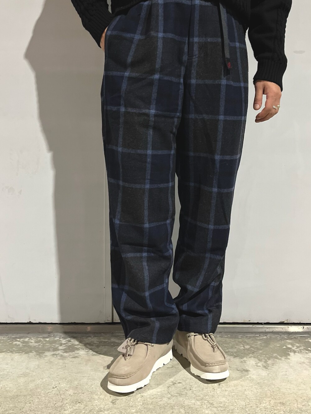 ブラック系のニット/セーター、ブルー系のスラックス、グリーン系のブルゾンを着用したメンズの秋コーディネートの4枚目の写真