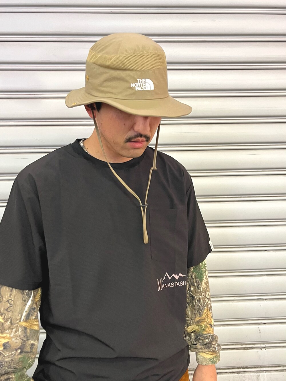 ブラウン系のデニムパンツ、ホワイト系のトートバッグ、ブラック系のTシャツ/カットソーを着用したメンズの秋コーディネートの2枚目の写真