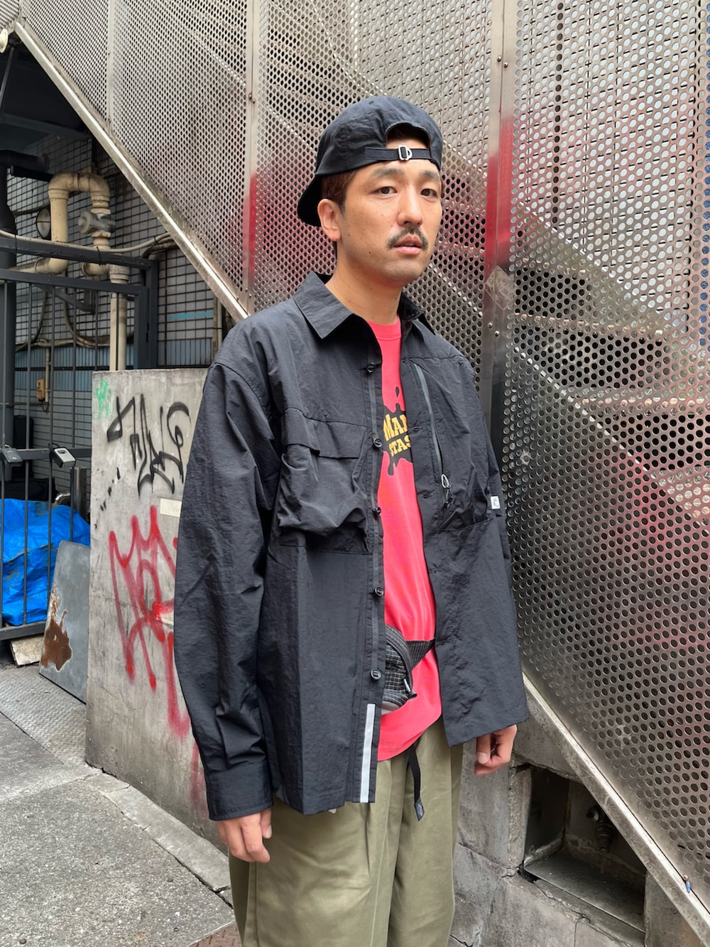 ブラック系のシャツ/ブラウス、ブラック系のその他パンツ、レッド系のTシャツ/カットソーを着用したメンズの秋コーディネートの2枚目の写真