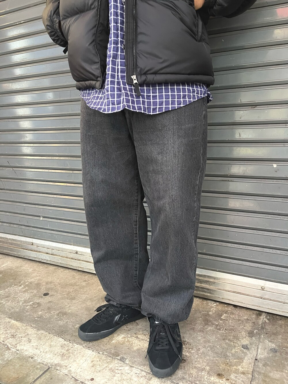 ブラック系のダウンジャケット/コート、ブラック系のデニムパンツ、ブルー系のシャツ/ブラウスを着用したメンズの秋コーディネートの3枚目の写真