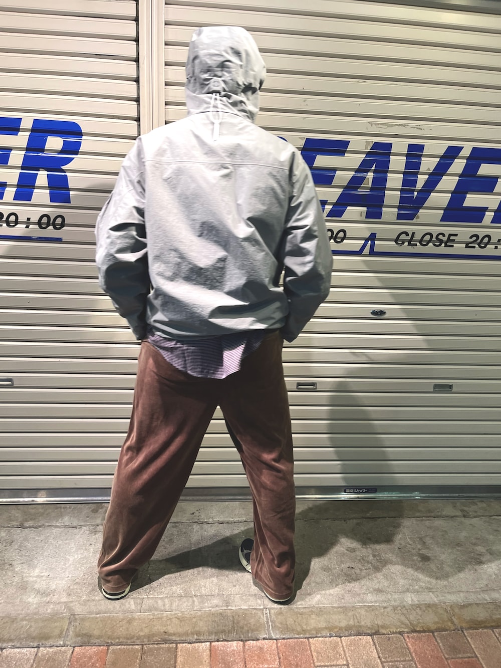 グレー系のマウンテンパーカー、ブラウン系のパンツ、ブラック系のシューズを着用したメンズの秋コーディネートの2枚目の写真