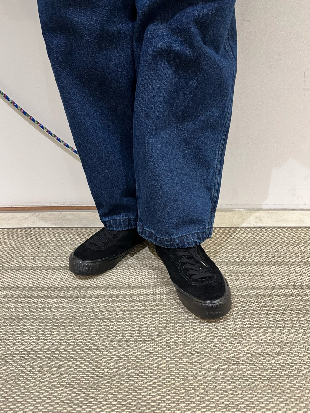 ブルー系のパンツ、ブラック系のTシャツ/カットソー、ブラック系のダウンベストを着用したメンズの秋コーディネートの3枚目の写真