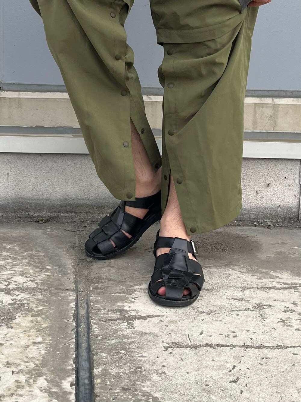 グリーン系のカーゴパンツ、ブラック系のシャツ/ブラウス、ブラック系のサンダルを着用したメンズの夏コーディネートの3枚目の写真