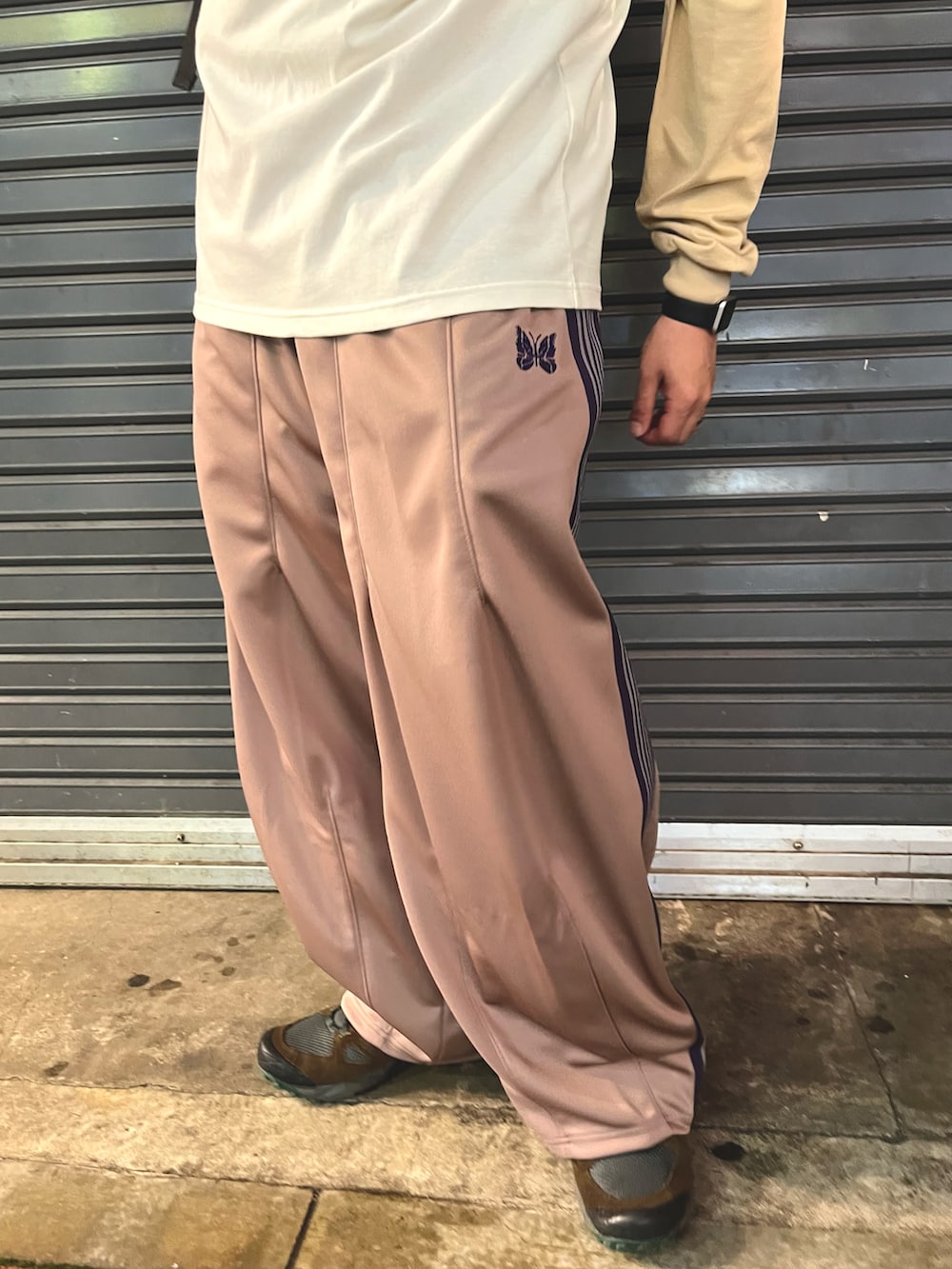 ホワイト系のTシャツ/カットソー、ベージュ系のパンツ、ブラック系のバックパック/リュックを着用したメンズの夏コーディネートの3枚目の写真