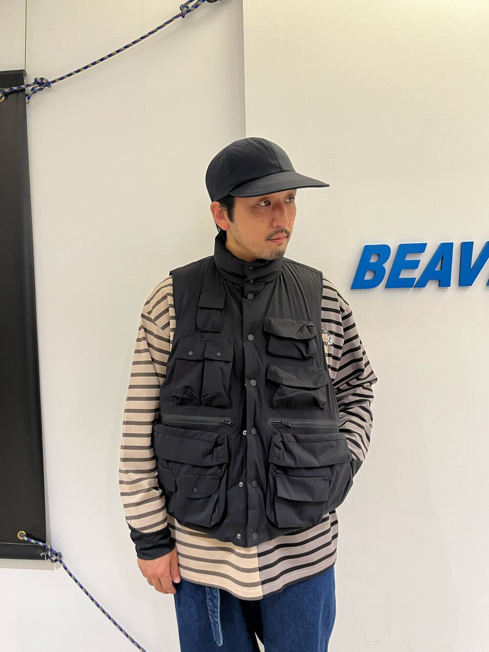ブルー系のパンツ、ブラック系のTシャツ/カットソー、ブラック系のダウンベストを着用したメンズの秋コーディネートの2枚目の写真