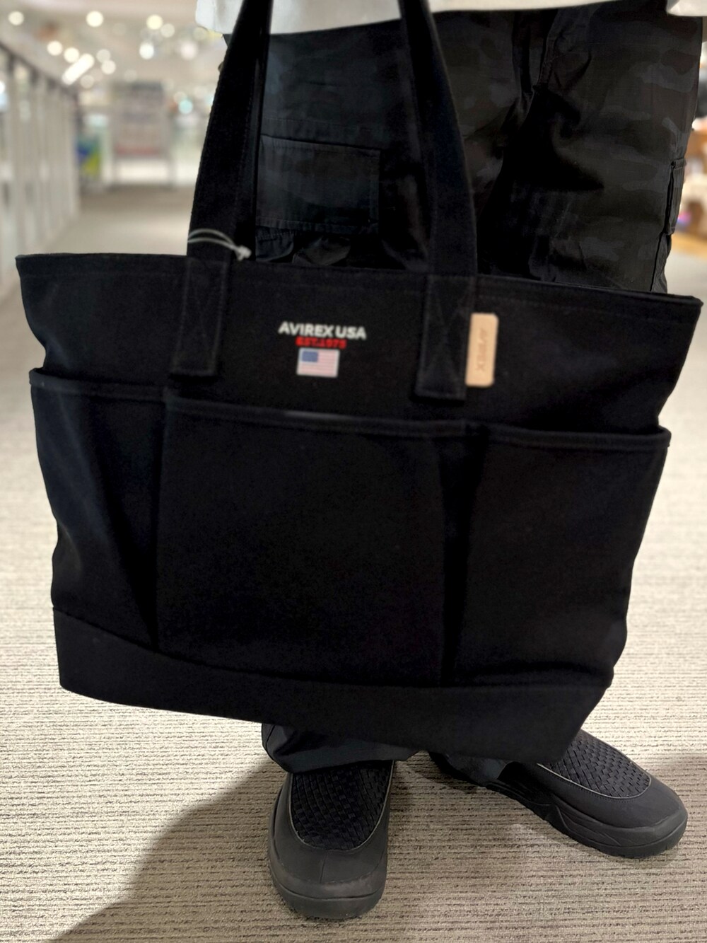 ブラック系のトートバッグ、その他のカーゴパンツ、ホワイト系のTシャツ/カットソーを着用したメンズの夏コーディネートの3枚目の写真