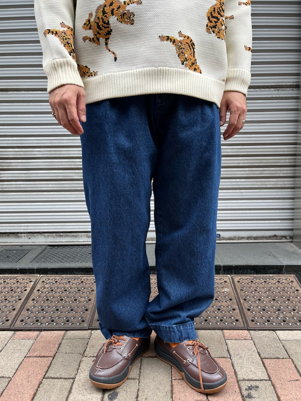 ホワイト系のニット/セーター、ブルー系のパンツ、ブラウン系のモカシン/デッキシューズを着用したメンズの秋コーディネートの3枚目の写真