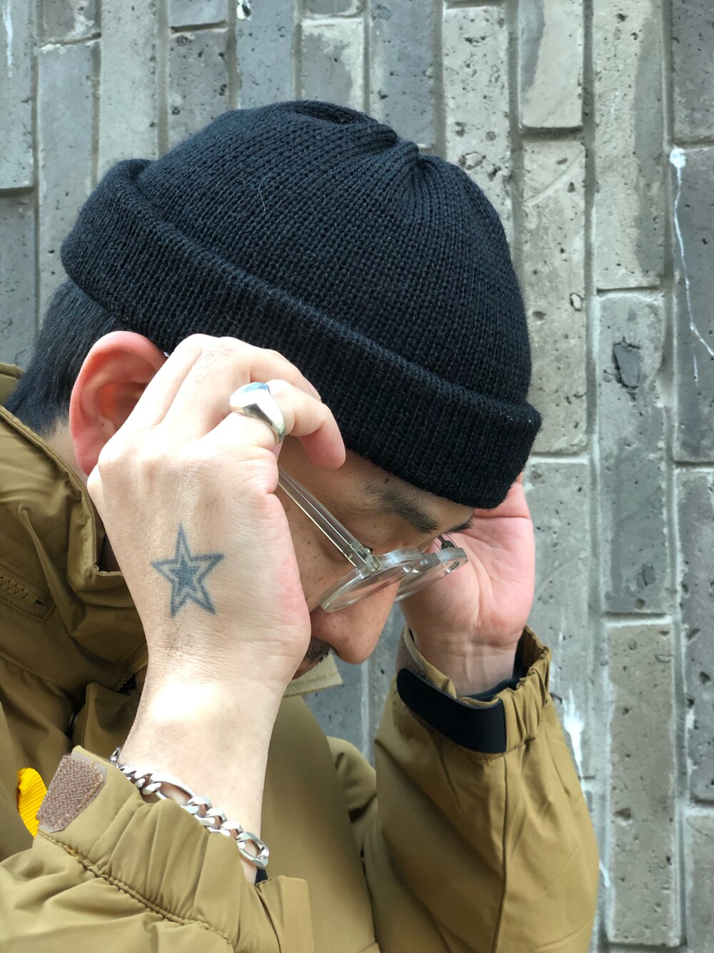 ブラック系のスウェットパンツ、ベージュ系のステンカラーコート、ブラック系のニットキャップ/ビーニーを着用したメンズの冬コーディネートの2枚目の写真