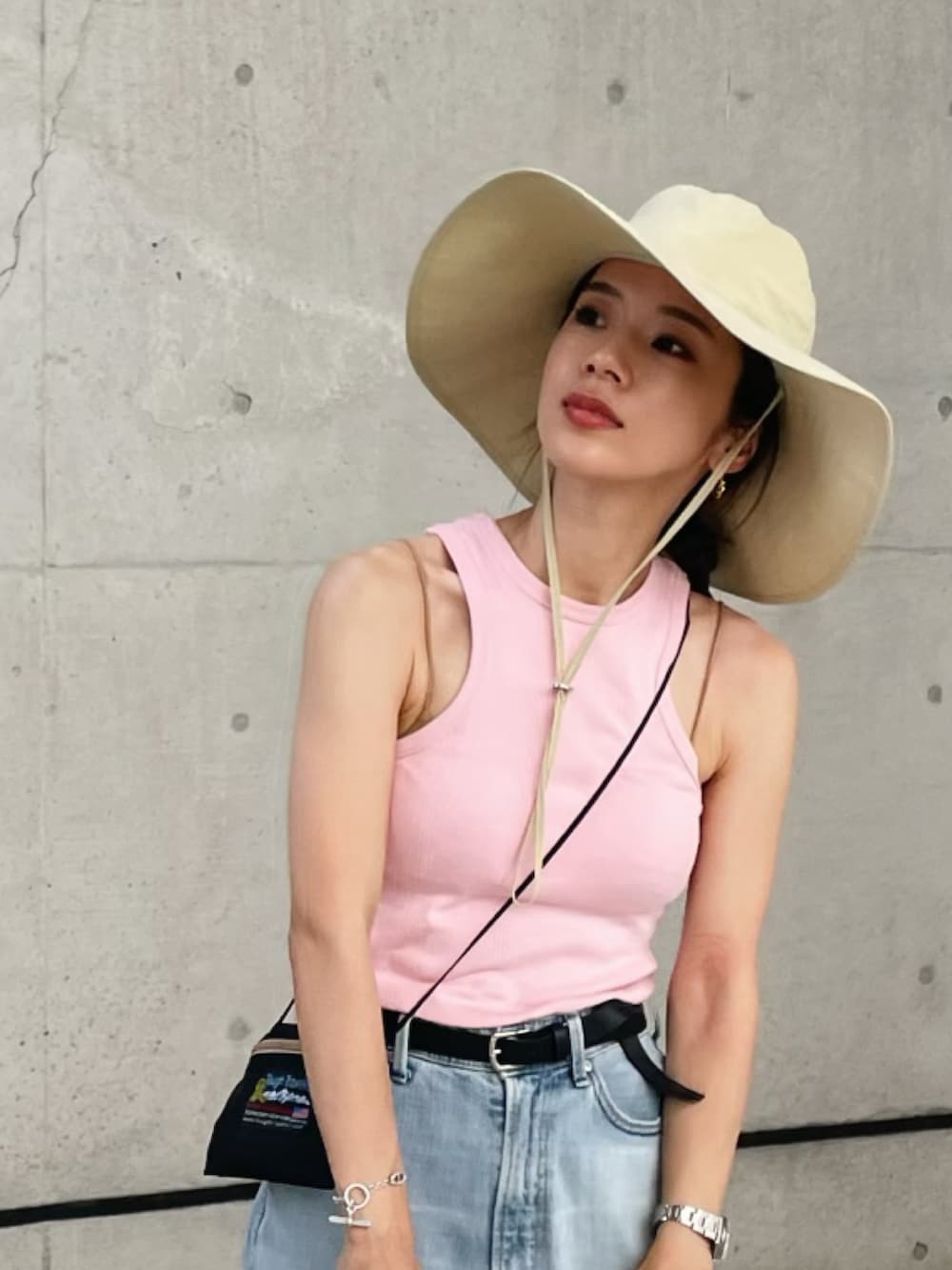 ピンク系のタンクトップ、その他のデニムパンツ、ホワイト系のスニーカーを着用したレディースの夏コーディネートの2枚目の写真