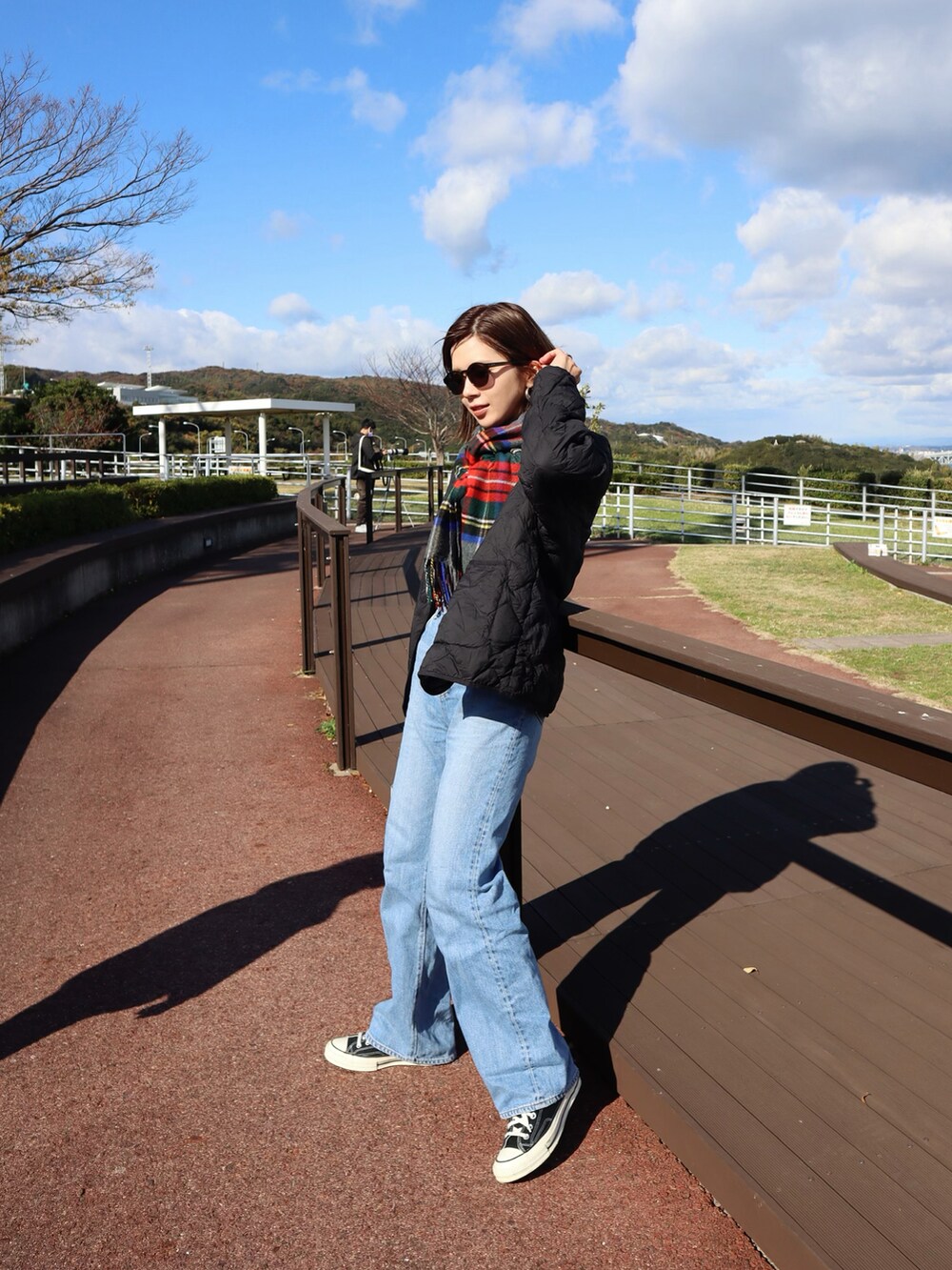 ブラック系のダウンジャケット/コート、ブラック系のニット/セーター、ブルー系のデニムパンツを着用したレディースの秋コーディネートの3枚目の写真