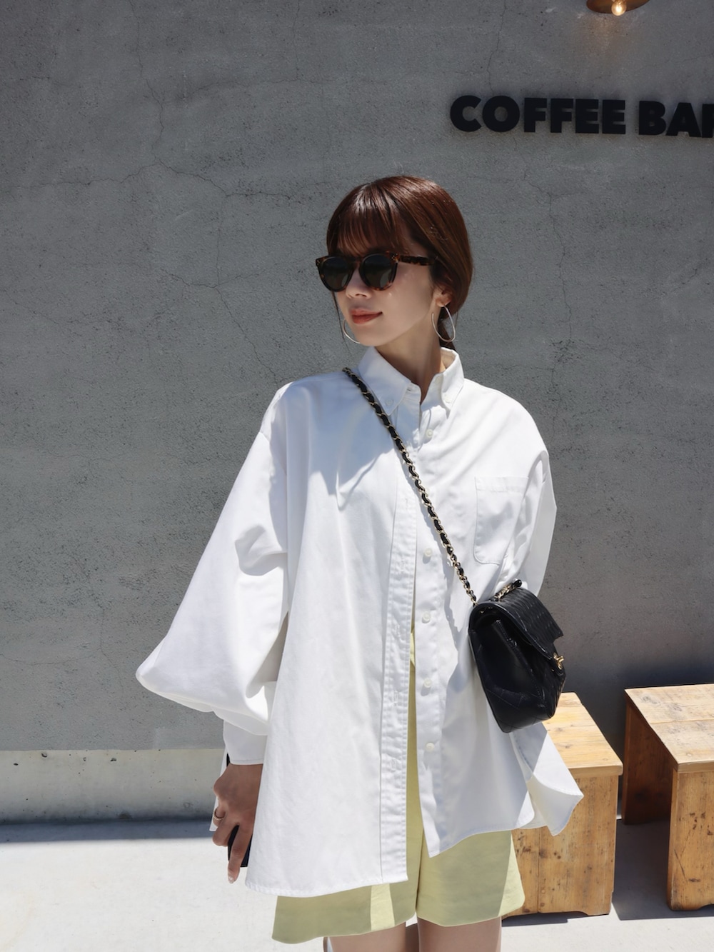 ホワイト系のシャツ/ブラウス、イエロー系のパンツ、ホワイト系のスニーカーを着用したレディースの春コーディネートの2枚目の写真