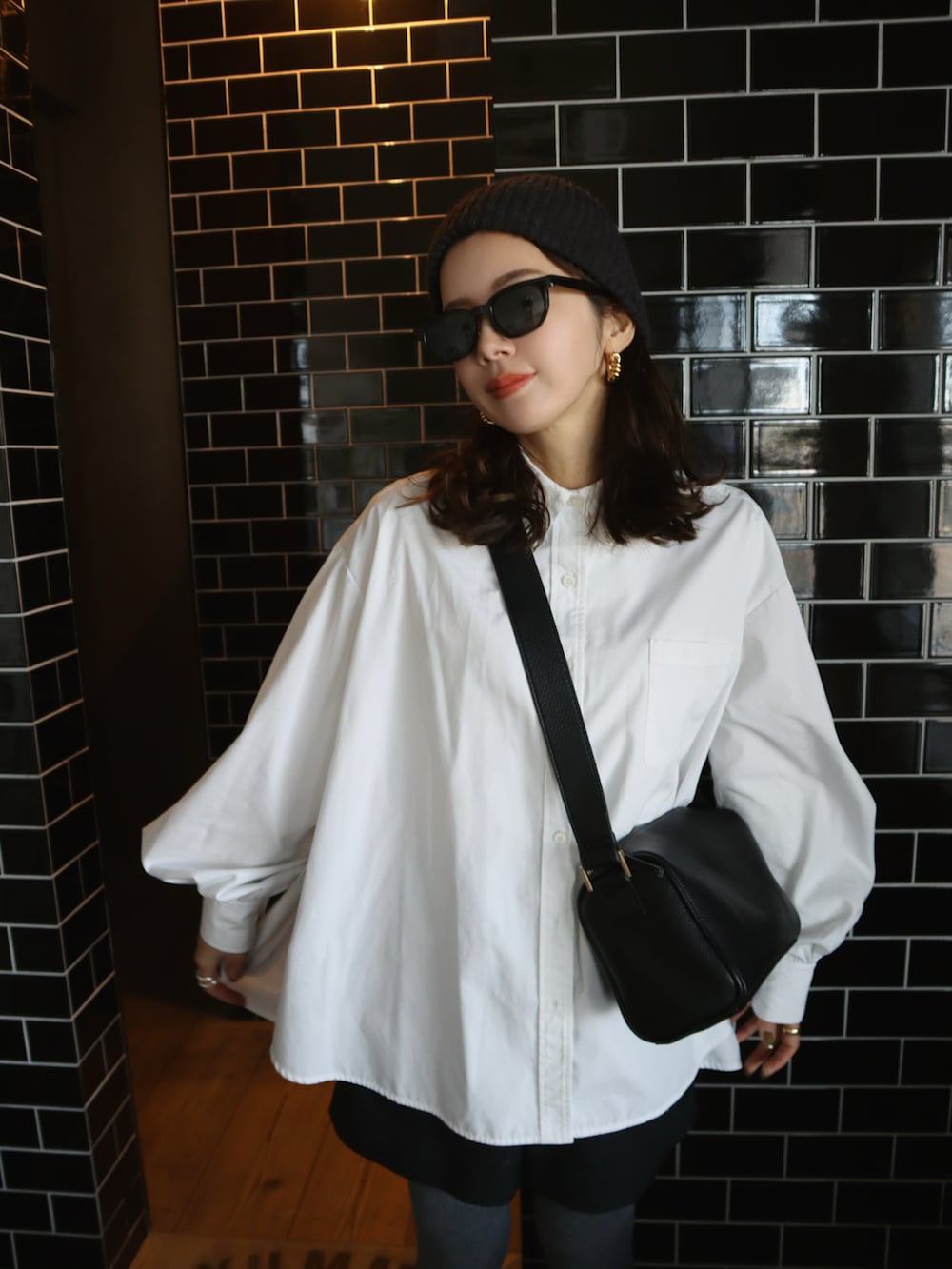 ホワイト系のシャツ/ブラウス、ブラック系のスニーカー、グレー系のニットキャップ/ビーニーを着用したレディースの冬コーディネートの2枚目の写真