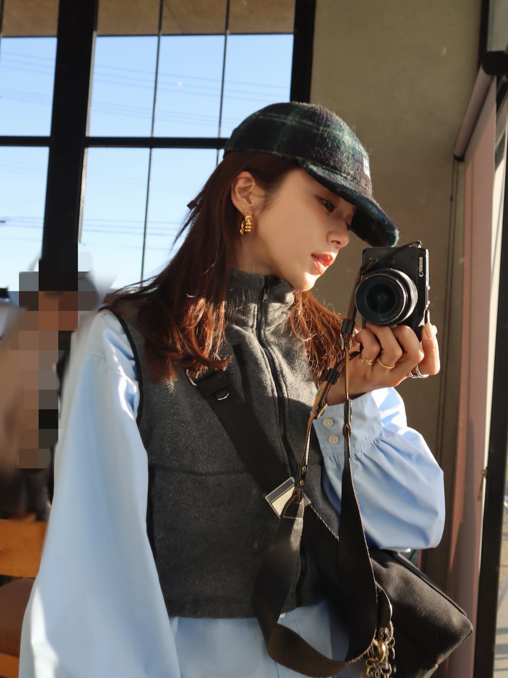 グレー系のベスト、ブラック系のスニーカー、グレー系のタイツ/ストッキングを着用したレディースの冬コーディネートの2枚目の写真