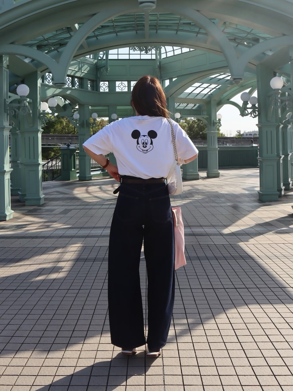 ホワイト系のTシャツ/カットソー、ブルー系のデニムパンツ、ピンク系のトートバッグを着用したレディースの春コーディネートの2枚目の写真