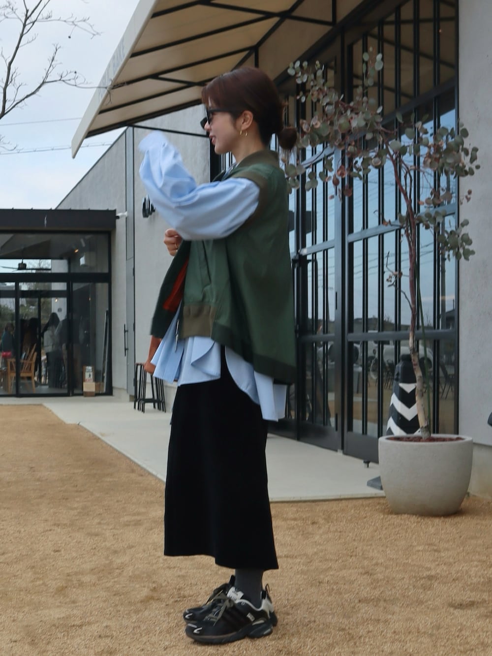 ブラウン系のハンドバッグ、ブルー系のシャツ/ブラウス、グレー系のタイツ/ストッキングを着用したレディースの冬コーディネートの3枚目の写真