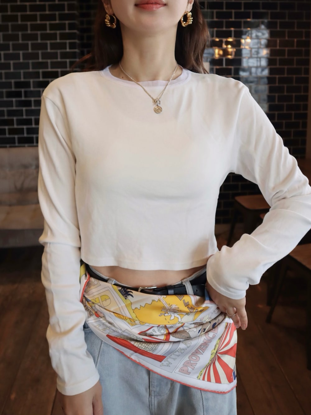 ホワイト系のTシャツ/カットソー、ブルー系のデニムパンツ、ブルー系のスニーカーを着用したレディースの春コーディネートの3枚目の写真