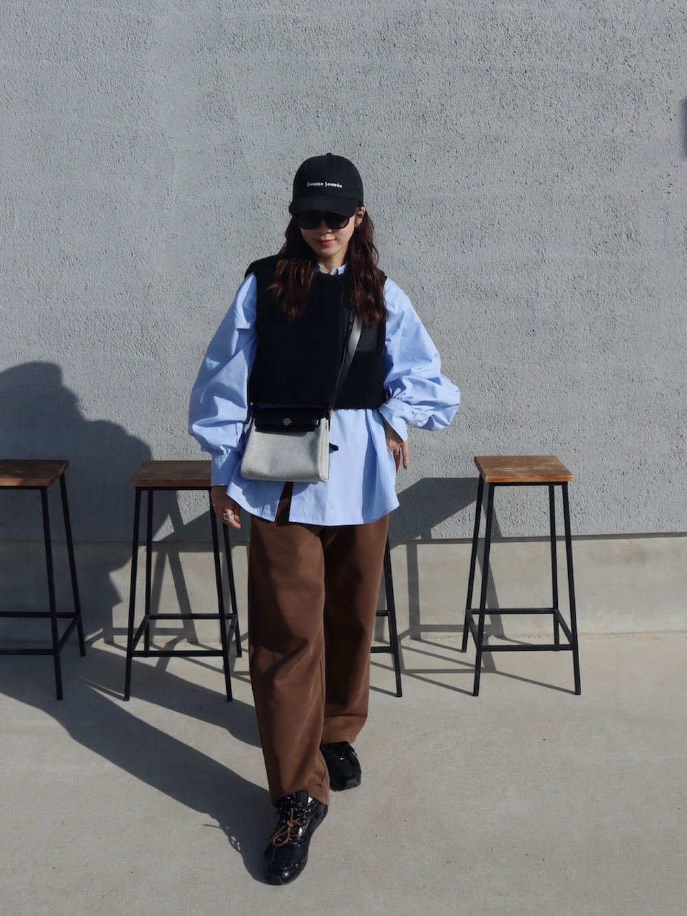 ブルー系のシャツ/ブラウス、ブラウン系のスウェットパンツ、ブラック系のキャップを着用したレディースの春コーディネートの2枚目の写真