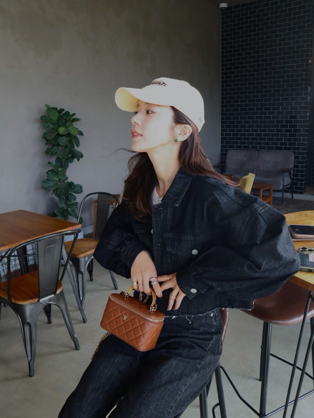 ブラウン系のスニーカー、ホワイト系のTシャツ/カットソー、ブラック系のデニムパンツを着用したレディースの冬コーディネートの2枚目の写真