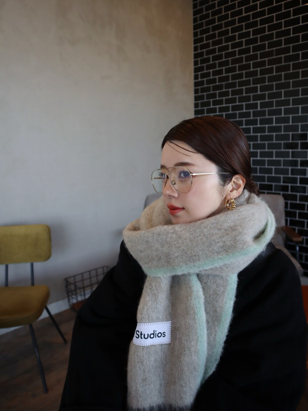 ブラック系のその他アウター、ブルー系のスニーカー、ベージュ系のチノパンツを着用したレディースの冬コーディネートの2枚目の写真